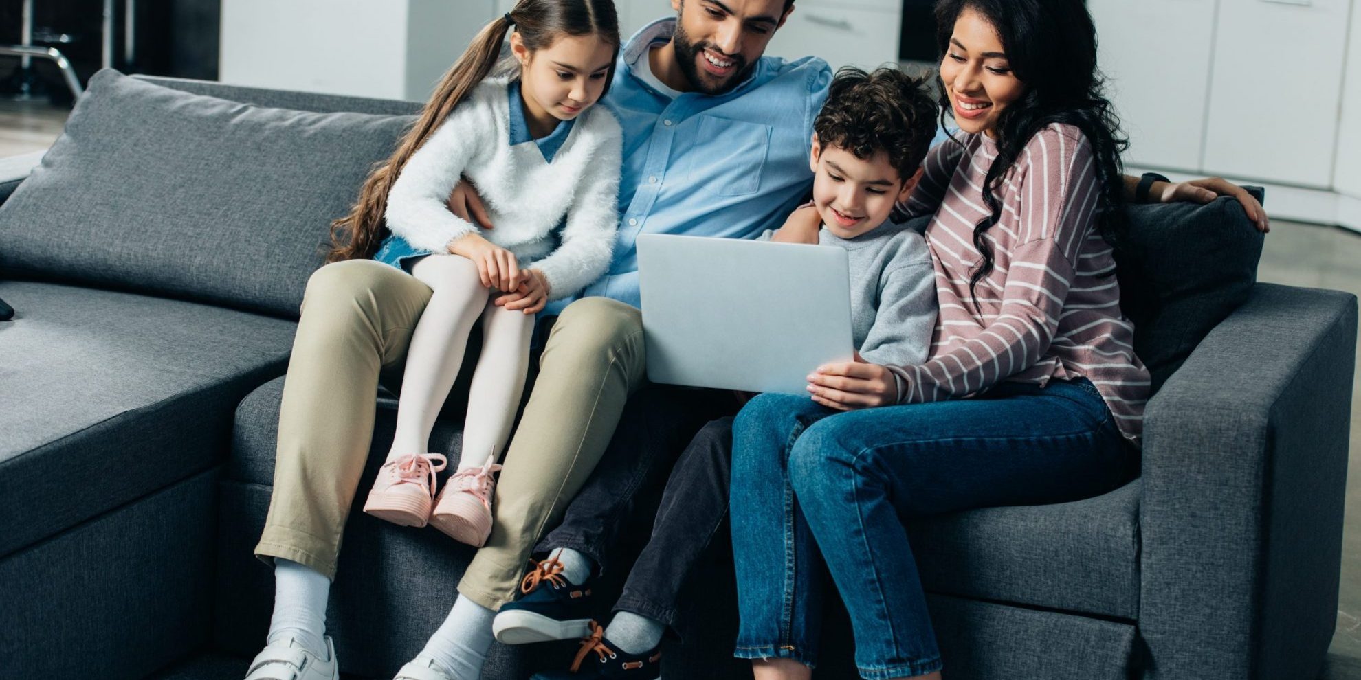 Foto de familia con laptop ilustra el blog "Asilo Político en los Estados Unidos: Algunos Términos que Necesitas Conocer (Parte I)"